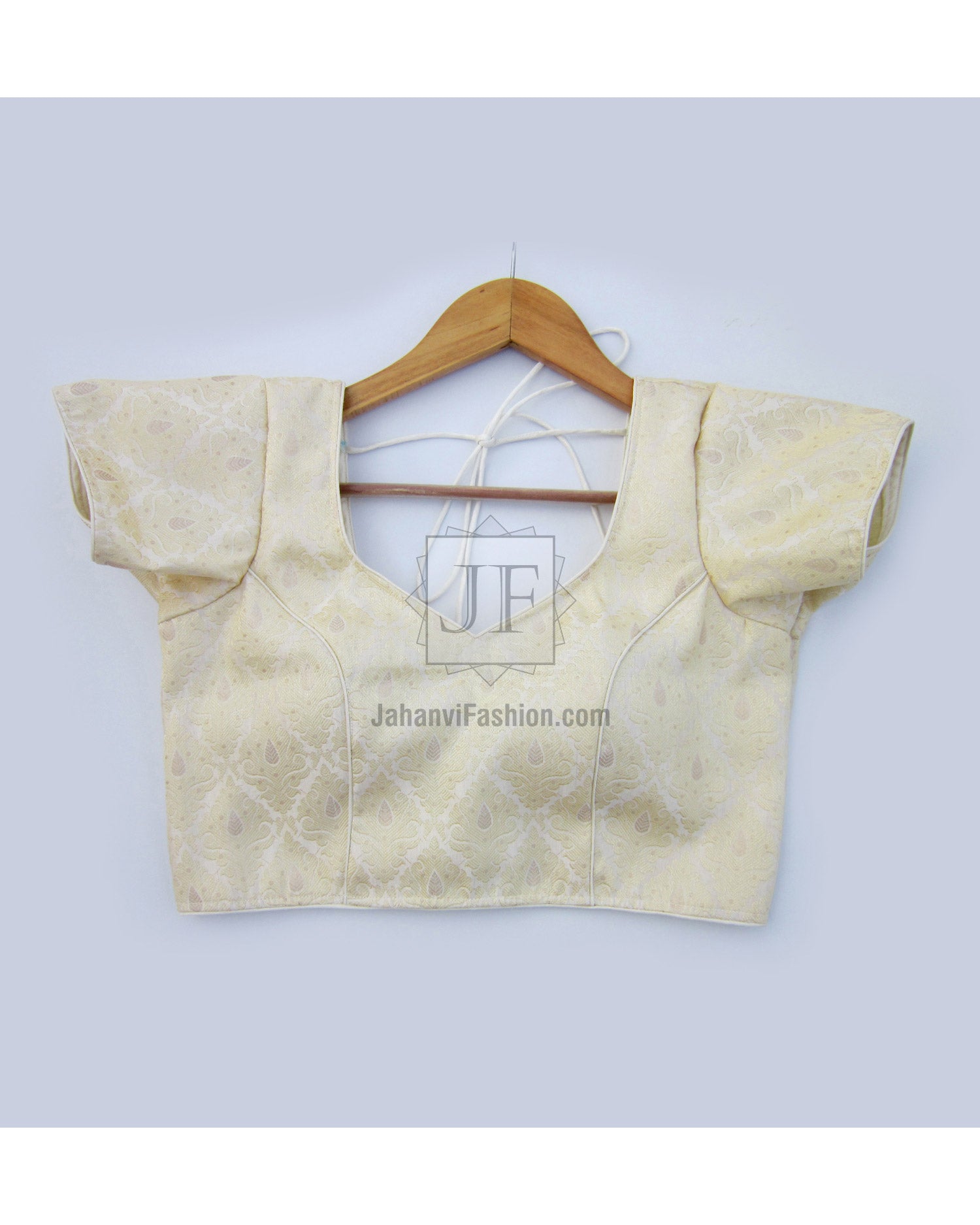 Cream-gold short-sleeve saree blouse with ornate brocade texture and square neckline.