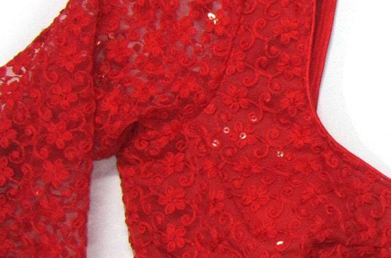 Close-up of red embroidered crop blouse fabric with floral sequin pattern