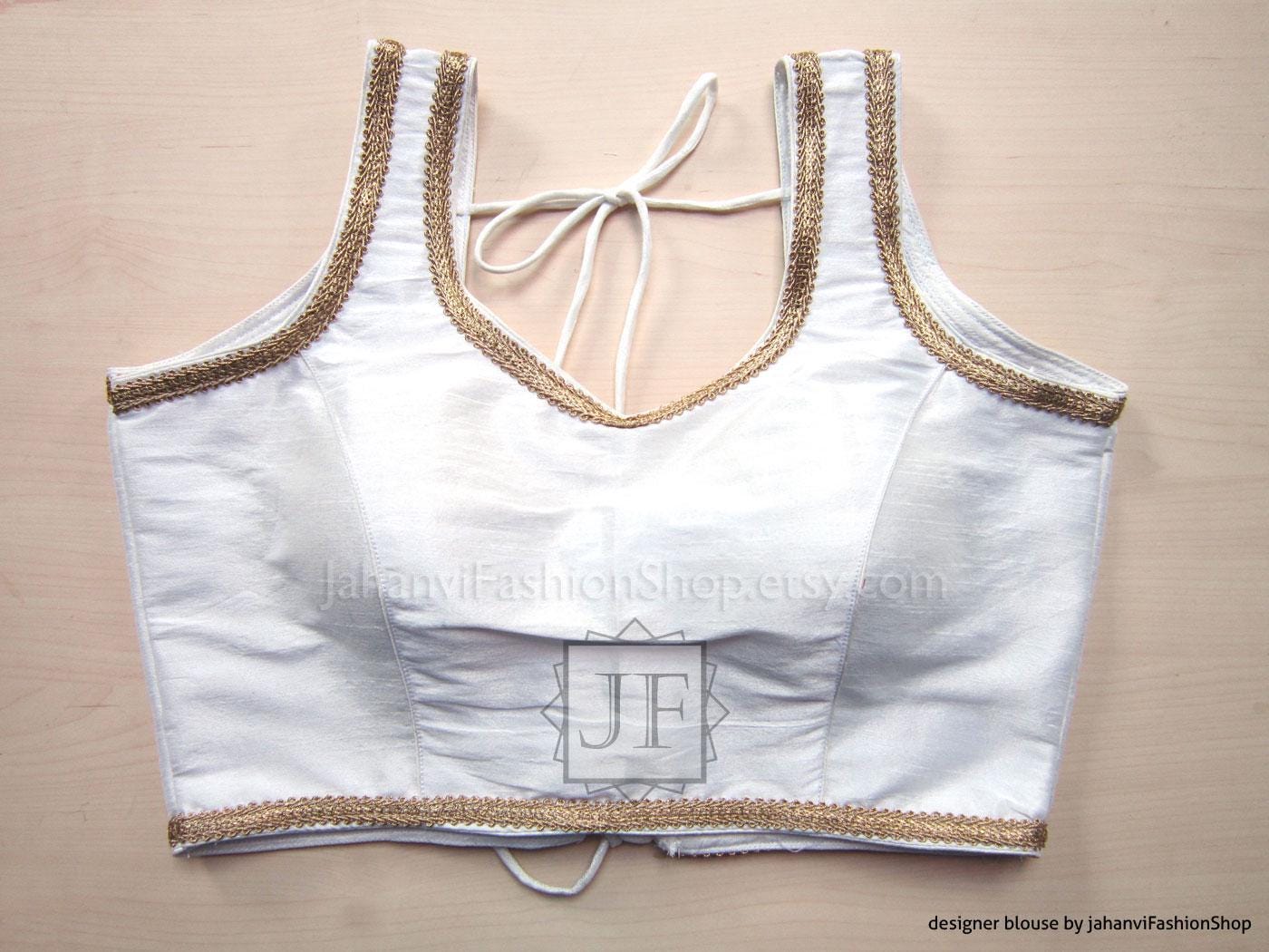 White sleeveless saree blouse with golden lace trim and tie-neck straps