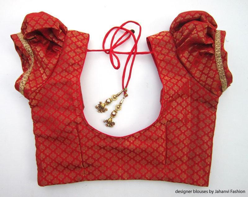 Red printed saree blouse with puff sleeves, deep neckline and tie-back cords with charms