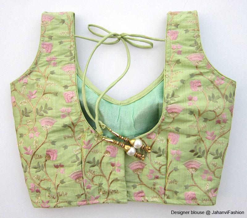 Embroidered princess-cut saree blouse, sleeveless with pink floral motifs and keyhole tie back.