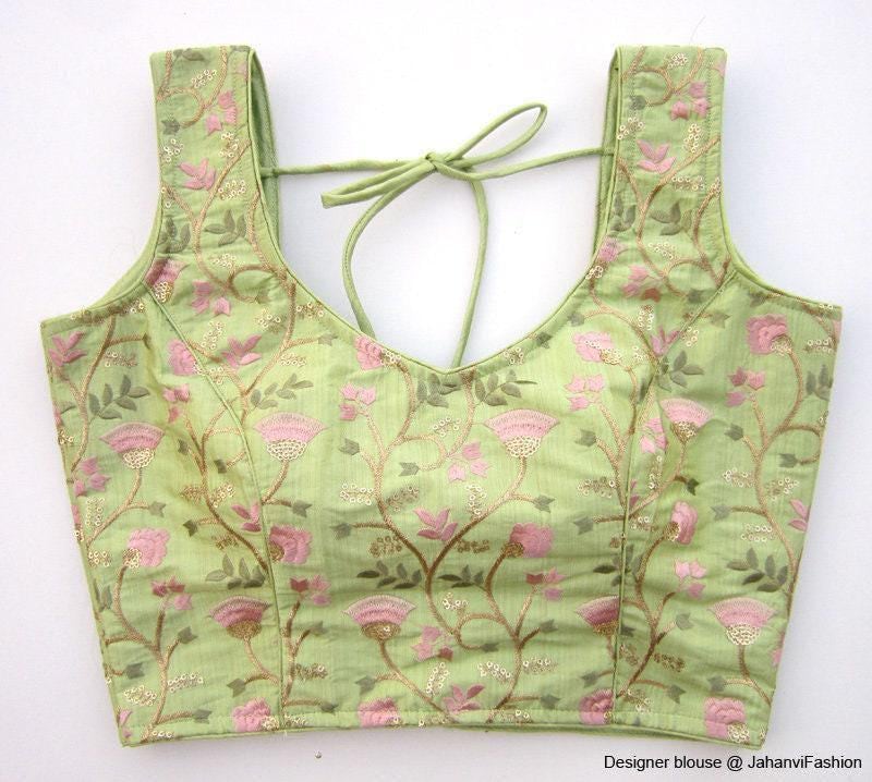 Embroidered princess-cut saree blouse, sleeveless with pink floral motifs and tie-back neckline.