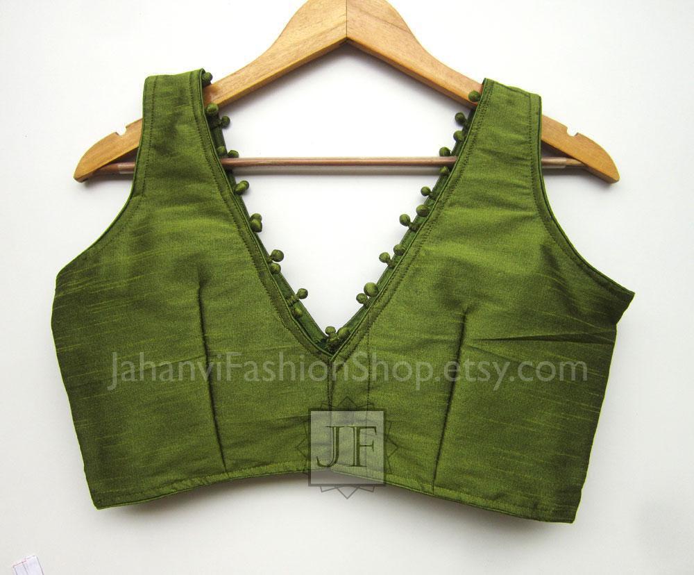 Olive-green v-neck sleeveless blouse with pom-pom trim and patterned hem
