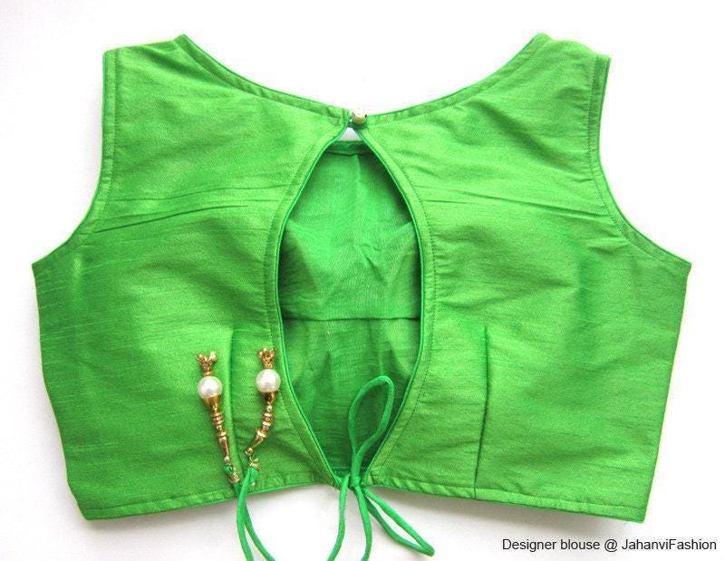 Green boat-neck sleeveless saree blouse with back tie closure and curved neckline