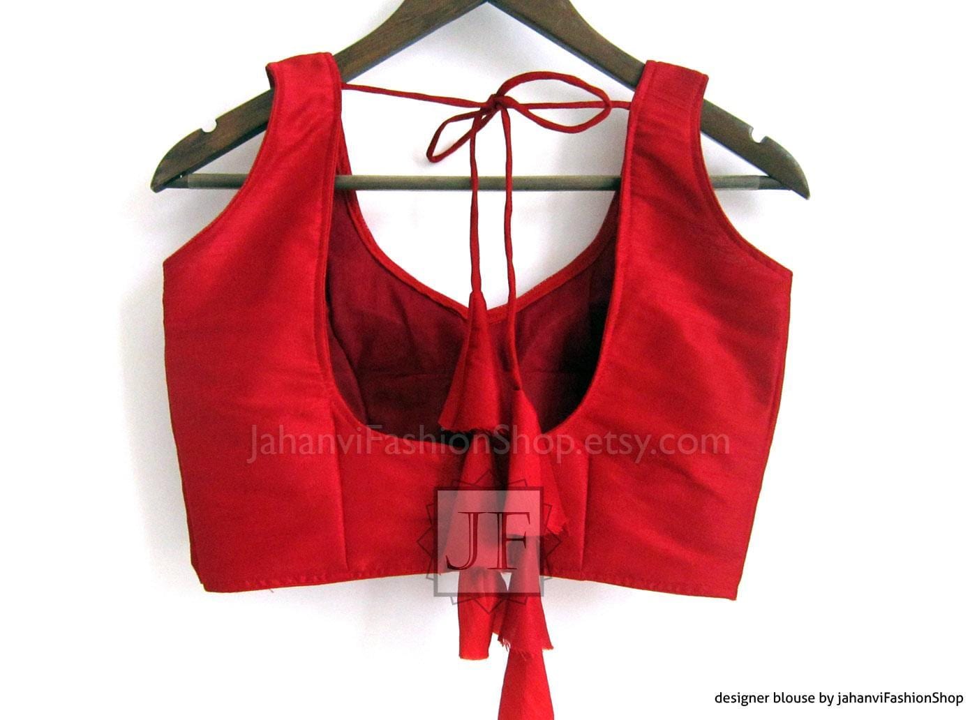 Red sleeveless saree blouse with tie-back neckline and princess-cut sleeve openings