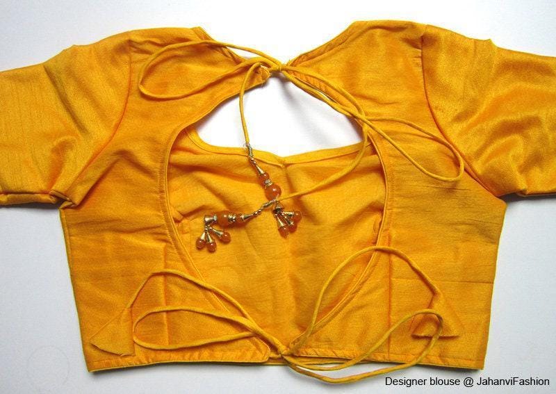Yellow backless saree blouse back view with tie-back strings and bead detail