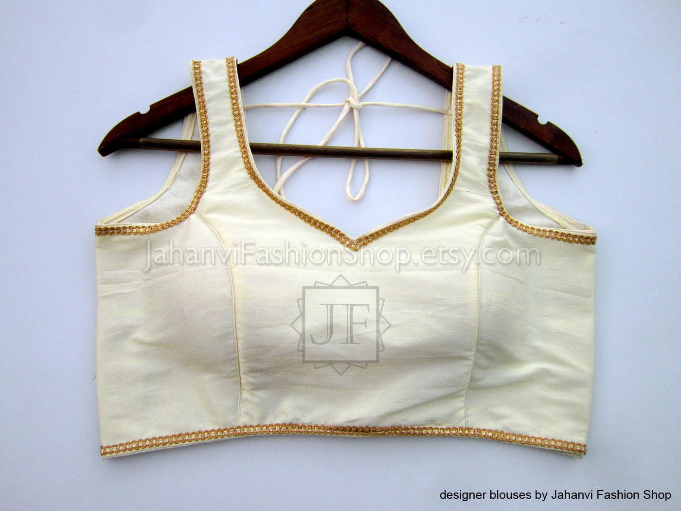 Cream saree blouse with golden lace trim, sleeveless V-neck front and back tie straps