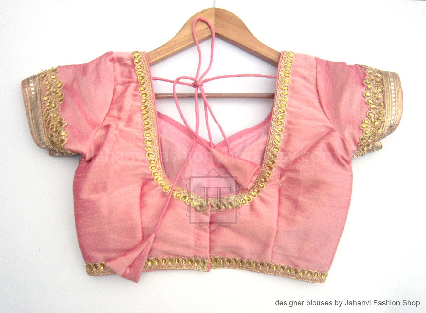 Pink bridal saree blouse with golden lace edges, short sleeves and crisscross back lacing