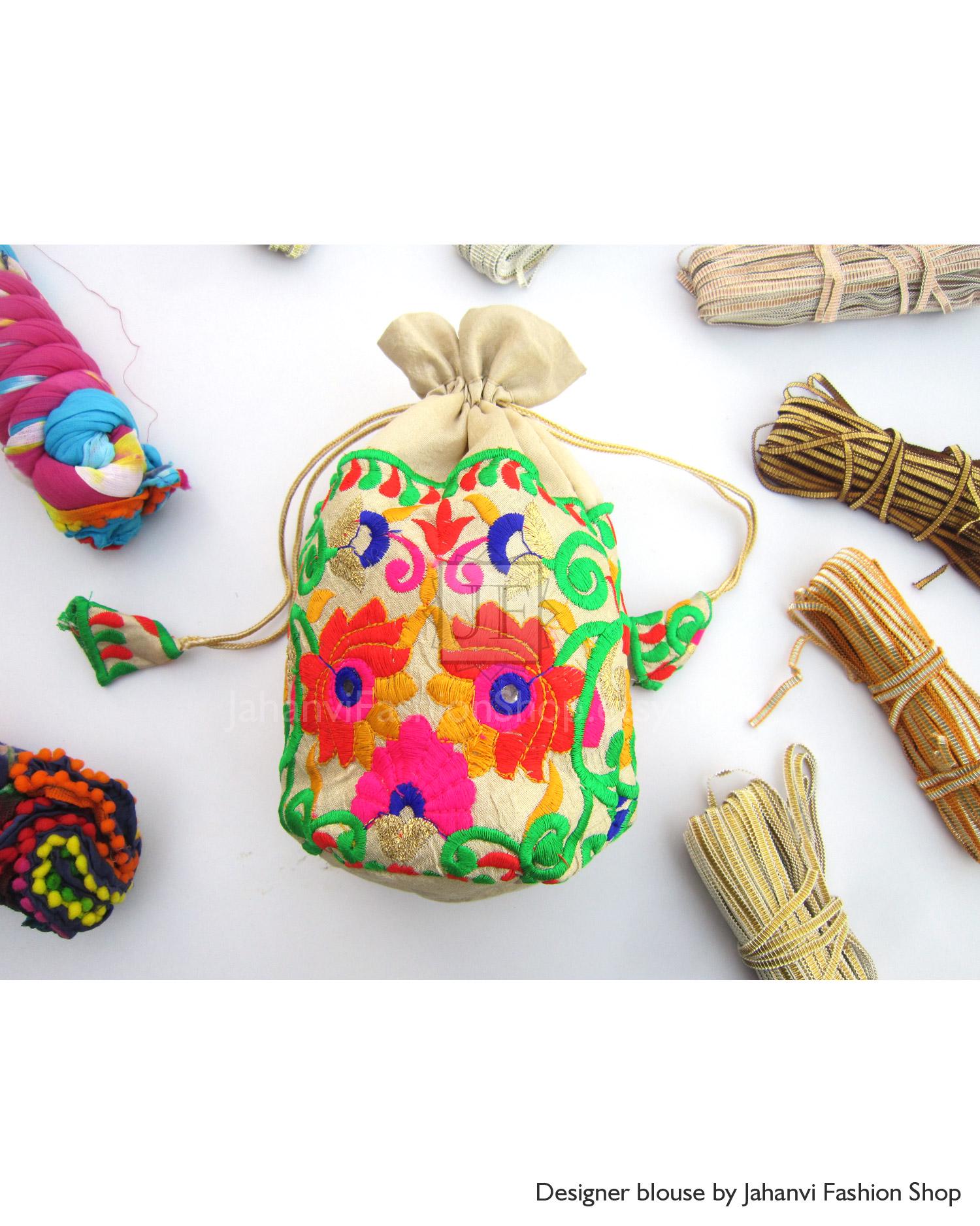 Embroidered wedding favor drawstring pouch, cream with colorful floral stitching.