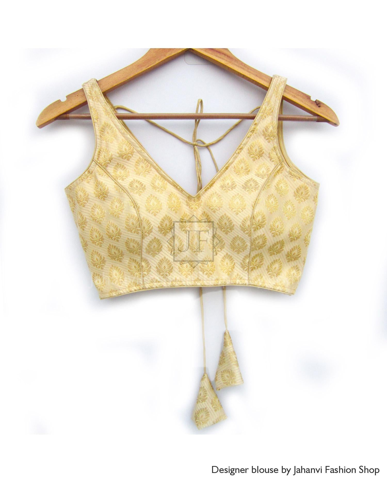 Gold patterned saree blouse with boat neckline, back tie strings, sleeveless cut on hanger