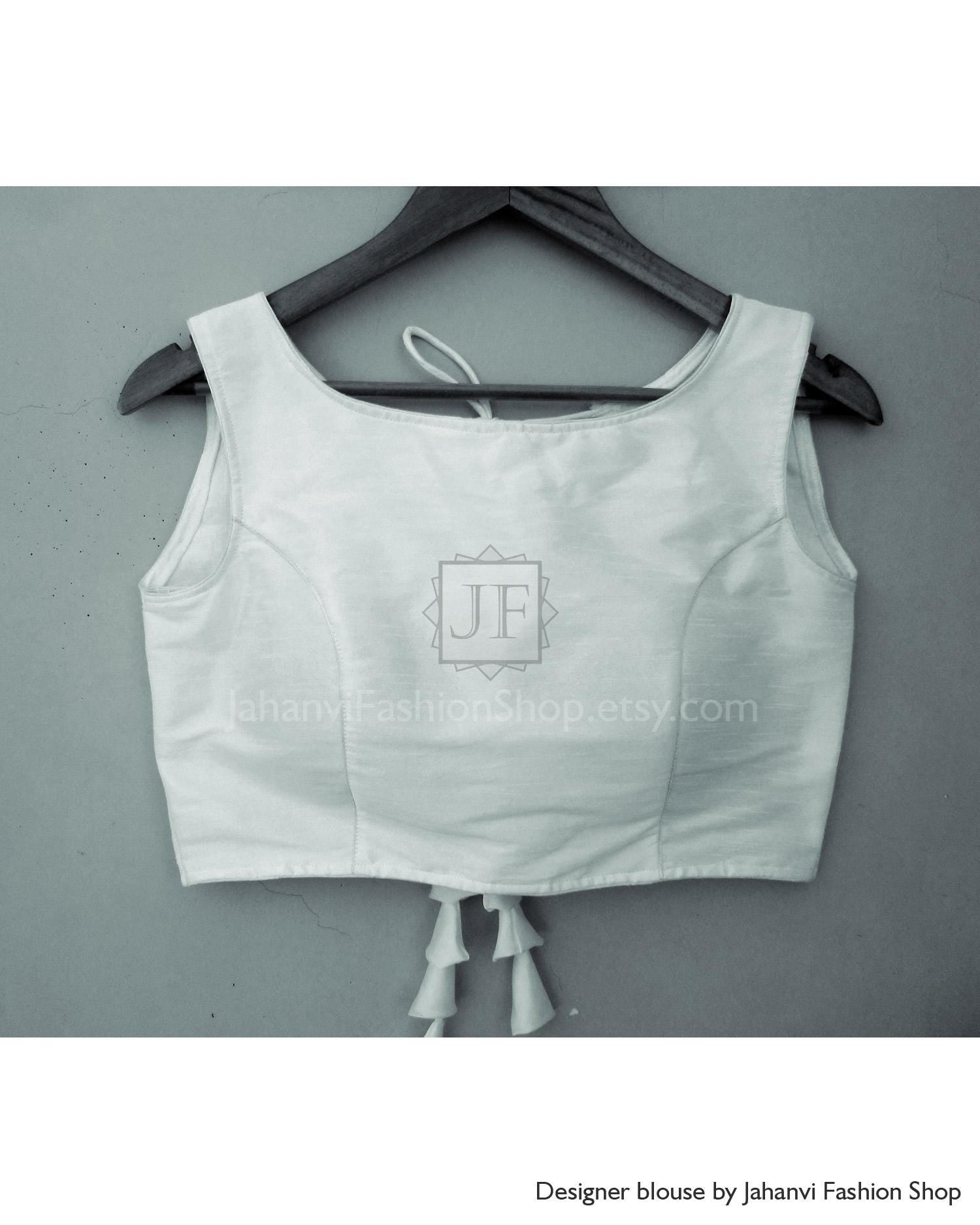 White boat-neck silk blouse, open back with shoulder ties and dangling tassels