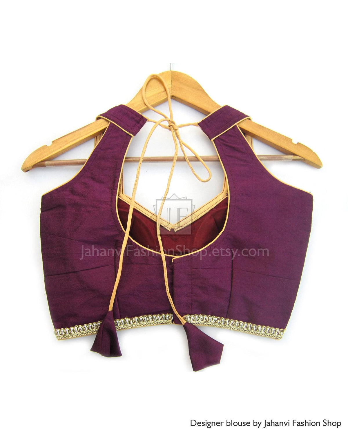 Sleeveless semi-halter saree blouse in deep maroon with golden trim and tie neck cords