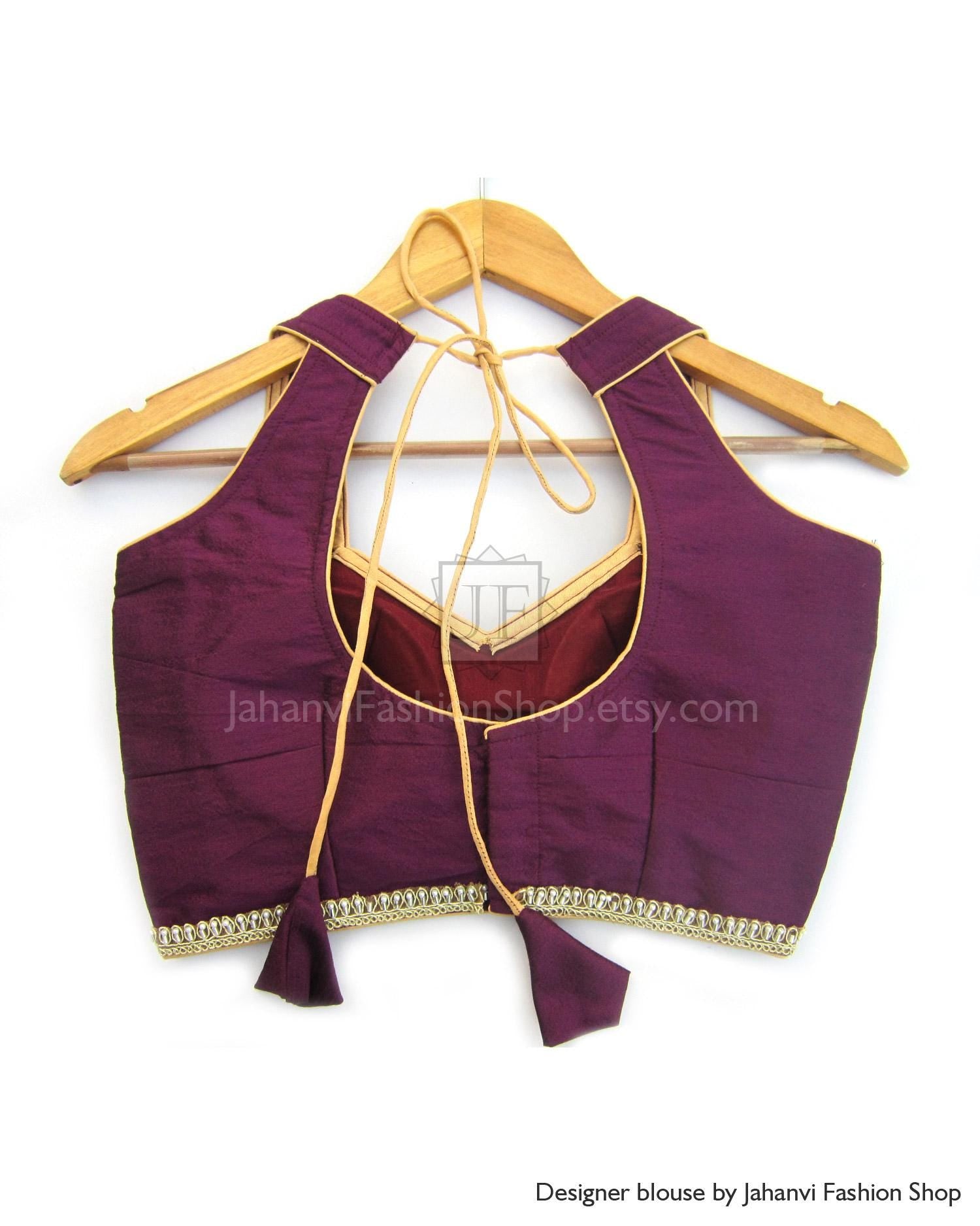 Sleeveless semi-halter saree blouse in deep maroon with golden trim and tie neck cords