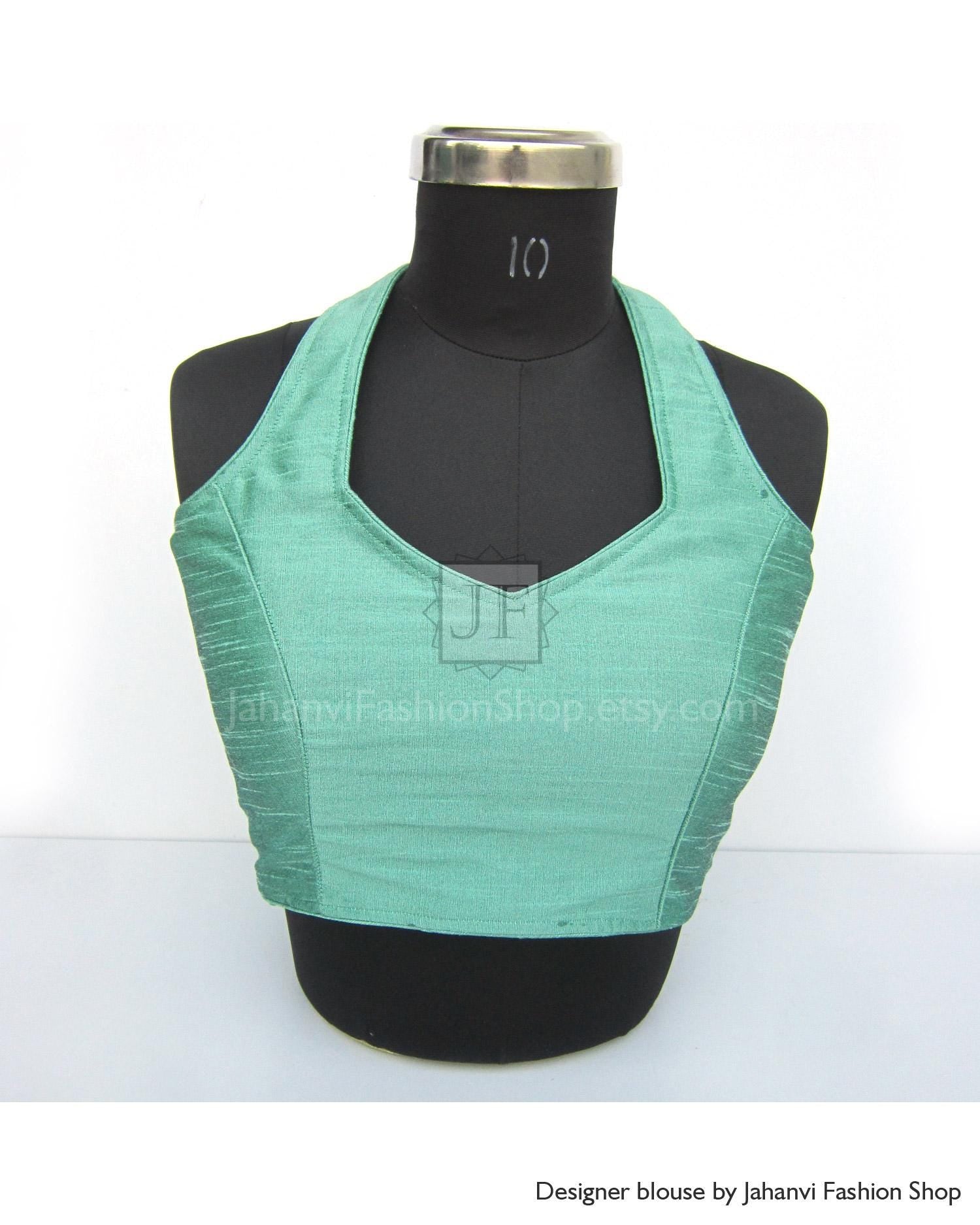 Turquoise halter neck saree blouse with deep neckline and princess cut seams