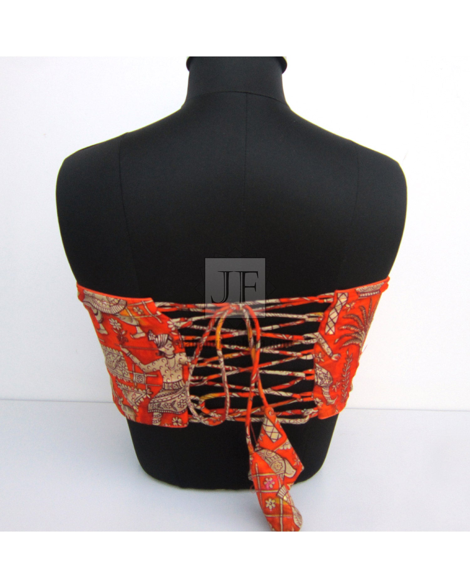 Sleeveless saree blouse back with crisscross tie straps on red-orange patterned fabric