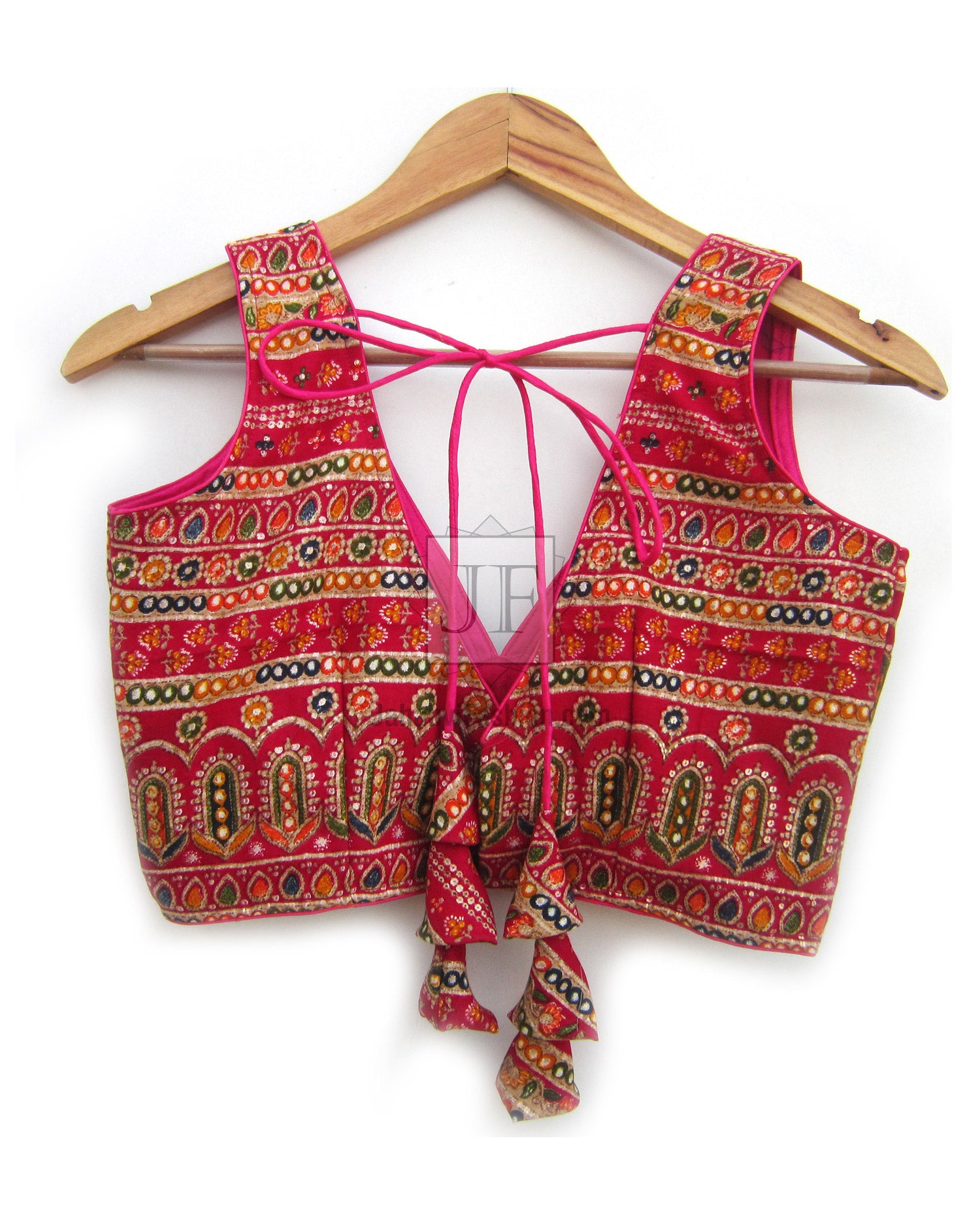 V-neck sleeveless blouse in magenta with gold patterned border and tie-back detail