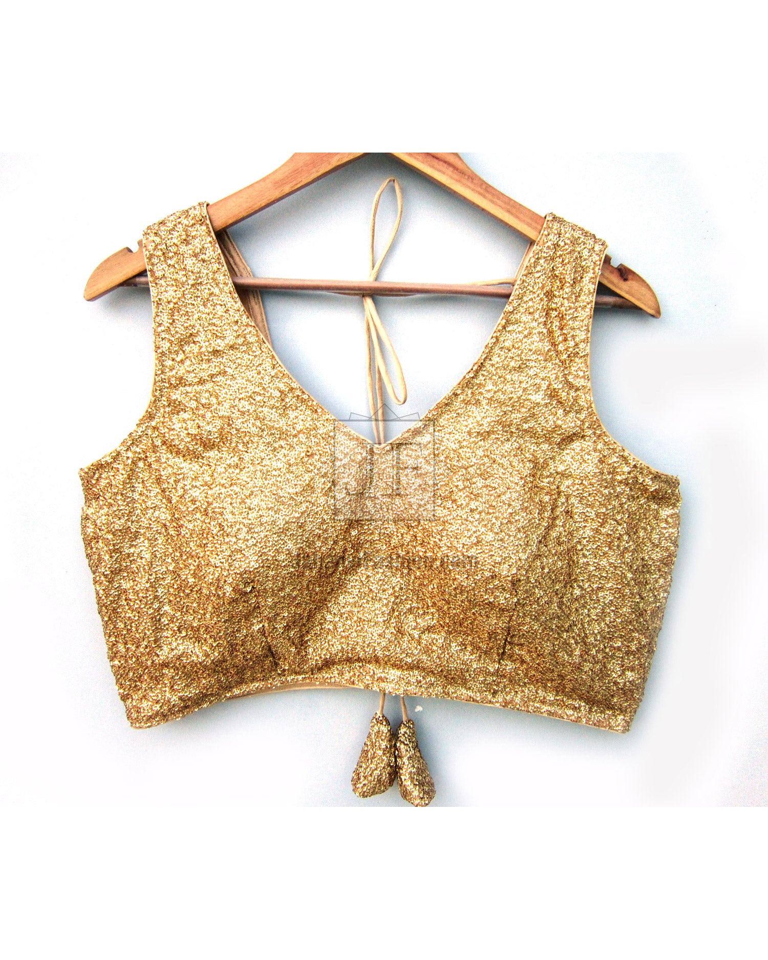 Gold sequined sleeveless blouse with scalloped neckline and bow tie-back