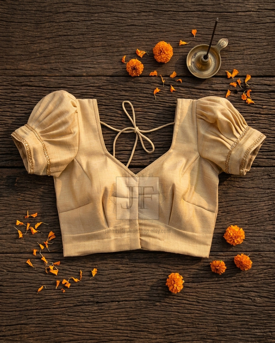 Golden shimmer puff-sleeve blouse with V-neck and front tie strings, flat lay